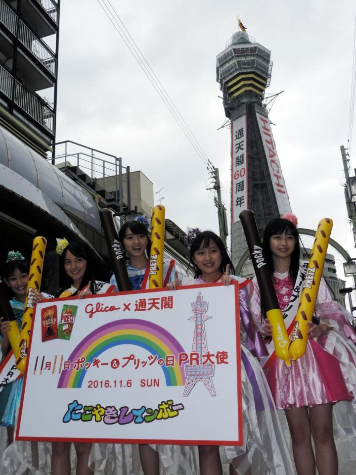 通天閣をバックに「ポッキー＆プリッツの日」をＰＲしたたこやきレインボーの（左から）根岸可蓮、清井咲希、春名真依、堀くるみ、彩木咲良＝大阪市の通天閣