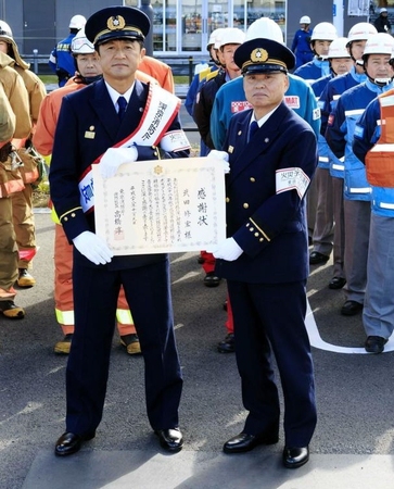 立川消防署の一日署長に任命され、訓練に参加する武田修宏（左）＝立川市内