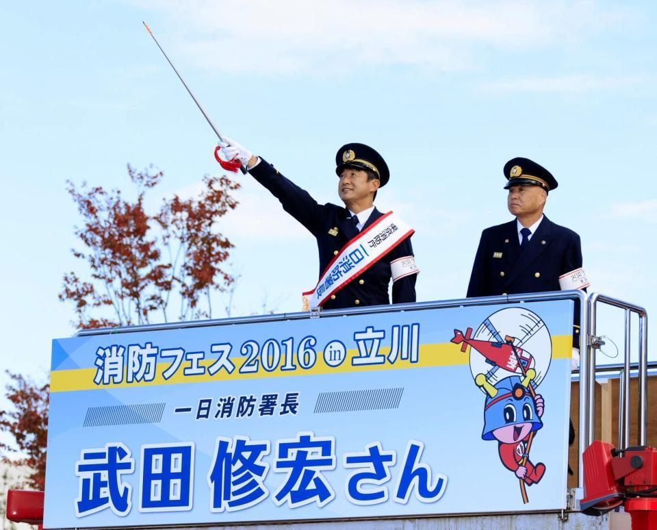 立川消防署の一日署長に任命され、訓練に参加する武田修宏（左）＝立川市内