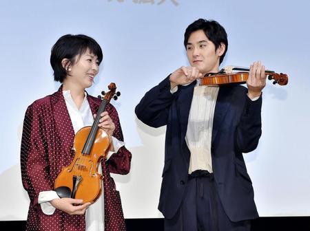 松たか子（左）の前でヴァイオリンを手にポーズを決める松田龍平（楽器提供・日本ヴァイオリン）＝スペースＦＳ汐留（撮影・園田高夫）