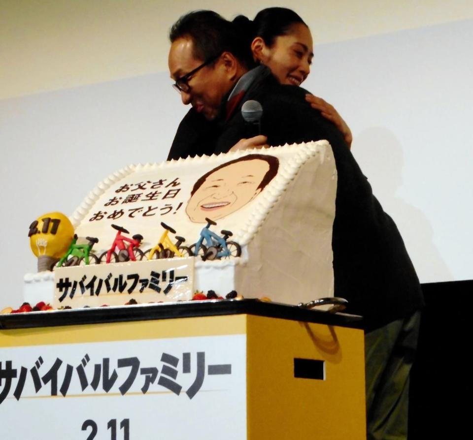 映画「サバイバルファミリー」の試写会でバースデーケーキを贈られた小日向文世（右）は深津絵里に感謝のハグ＝東京・スペースＦＳ汐留