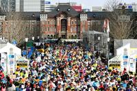 　新コースで開催された第１１回東京マラソンで、ゴールする大勢の市民ランナーら。奥はＪＲ東京駅＝２６日午後、東京都千代田区
