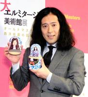 ロシア民族衣装を着た自身の人形を手にする又吉直樹＝東京・六本木ヒルズ