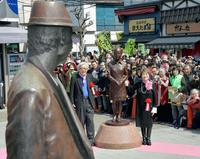 　お披露目されたさくら像と記念撮影する山田洋次監督（左）と倍賞千恵子。手前は寅さん像＝東京都葛飾区の柴又駅前