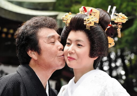 　２０１６年５月、結婚式後にみなこ夫人（右）にキスをする冠二郎