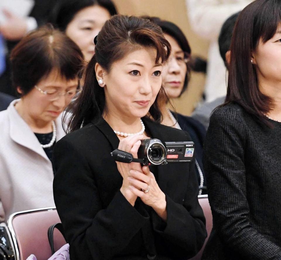 　晴れ姿を撮影する母・恵美子さん（中央）