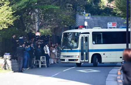 大勢の報道陣（左）の前を通過する坂口杏里容疑者が乗っていると思われる警察車両＝東京・原宿署（撮影・開出牧）