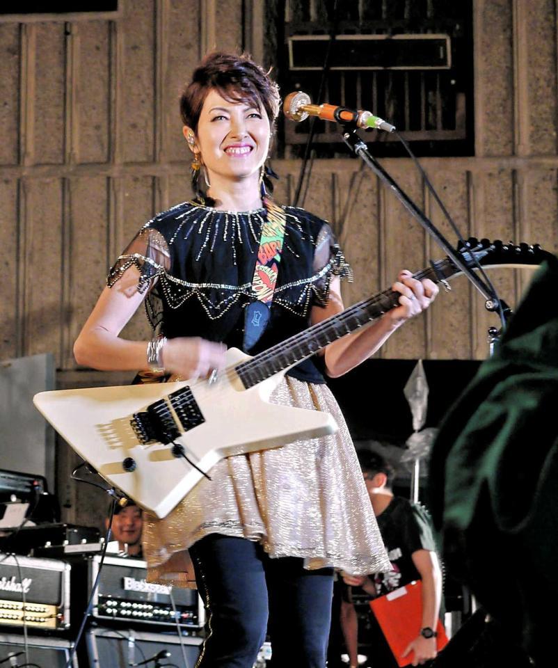 　ギターを弾き鳴らす荻野目洋子＝東京・日比谷野外音楽堂