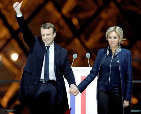　フランス大統領選で勝利し、集まった支持者にブリジット夫人と応えるマクロン氏＝７日、パリ（ロイター＝共同）