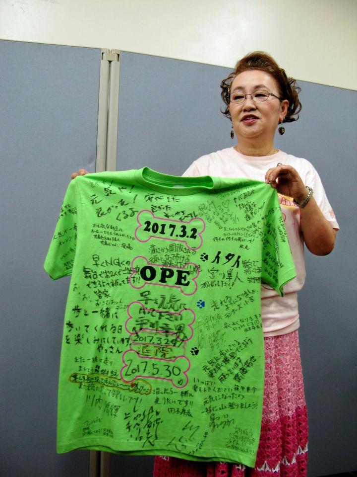 関係者からの寄せ書きＴシャツを見せる宮川花子＝大阪市内