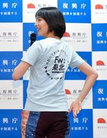 Ｔシャツの背中にあしらったプロジェクトロゴを披露するのん＝東京・復興庁（撮影・開出牧）