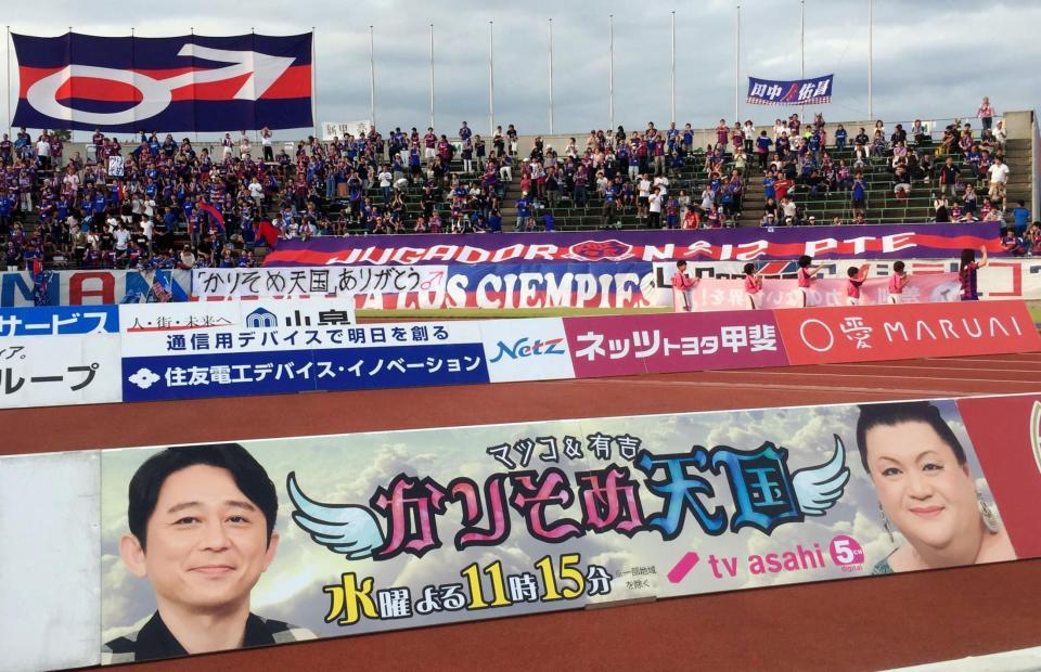 Ｊ１第１５節の甲府－柏戦で、テレビ朝日系で放送されている「マツコ＆有吉　かりそめ天国」の看板が掲載された＝山梨中銀スタジアム