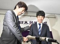 　将棋の公式戦連勝記録で歴代最多に並ぶ28連勝を達成し、師匠の杉本昌隆七段（左）と握手を交わす藤井聡太四段＝21日午後、大阪市の関西将棋会館