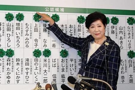 　都議選の開票が進み当選者の名前に花をつける小池百合子都知事＝東京・西新宿（撮影・堀内翔）