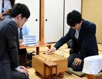 初手を打つ藤井聡太四段（右、左は対戦者の三枚堂達也四段）＝千駄ヶ谷・将棋会館（撮影・三好信也）