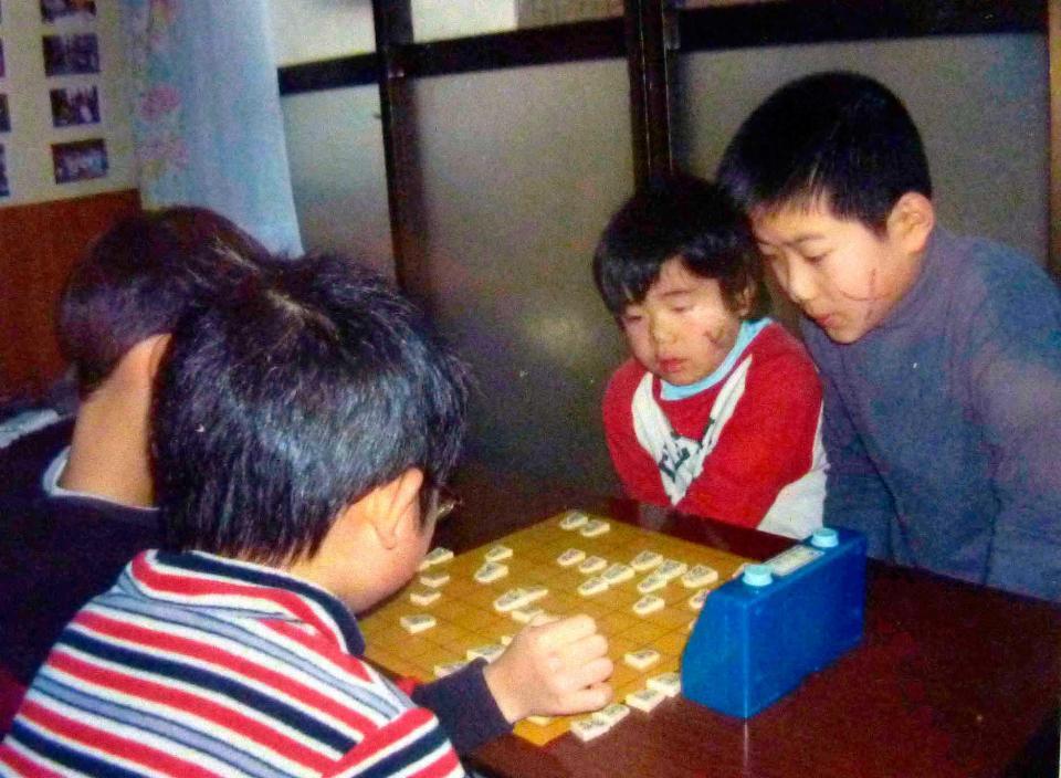 　将棋で負け、ほおにバツ印を書かれた小学１年ごろの藤井聡太四段（右から２人目）（家族提供）