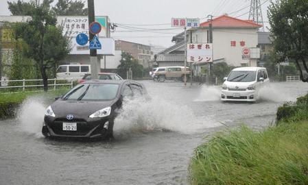 　台風１８号による大雨で冠水した道路を走る車＝大分市