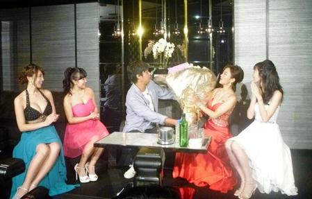 来店したパンサー・尾形貴弘（中央）から花束をもらう夏菜（右から２人目）＝東京・六本木