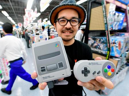 　発売された「ニンテンドークラシックミニ　スーパーファミコン」を手にする人＝大阪市