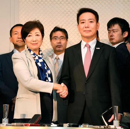 　会談後、報道陣の前で握手する民進党の前原代表（右）と希望の党代表の小池都知事＝東京都内のホテル