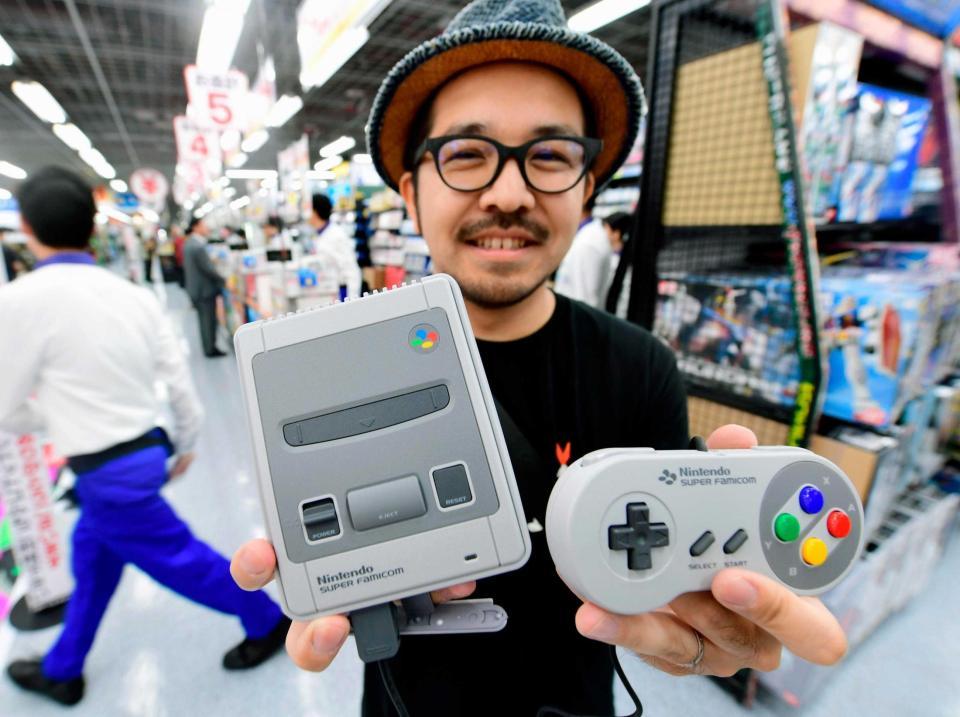 　発売された「ニンテンドークラシックミニ　スーパーファミコン」を手にする人＝大阪市