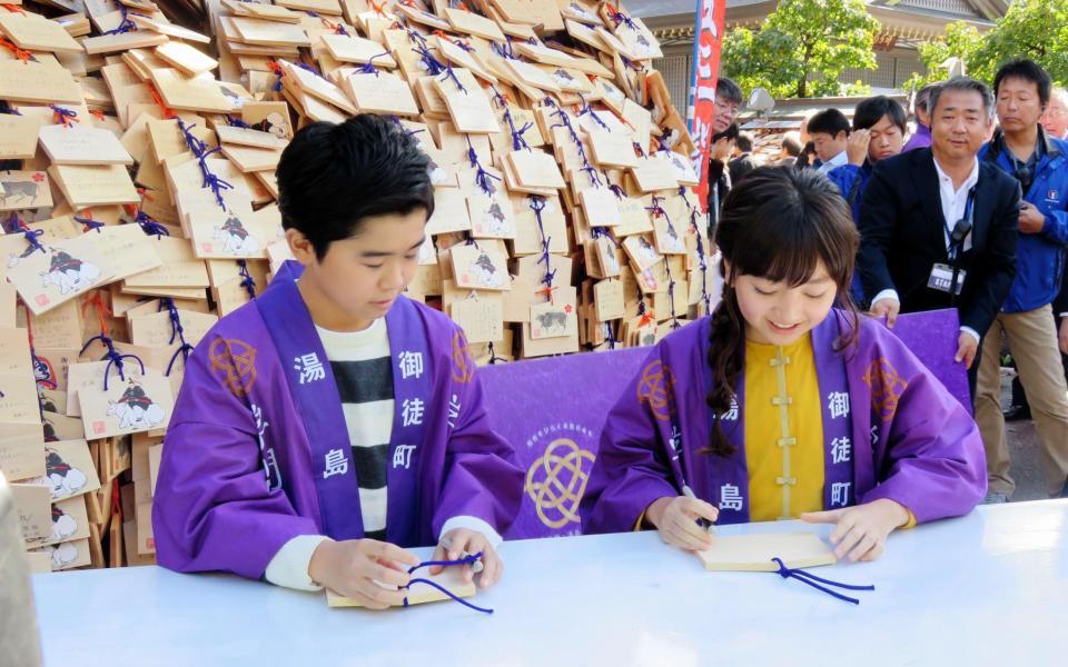 絵馬に願いごとを書く鈴木福（左）と谷花音＝東京・湯島天神