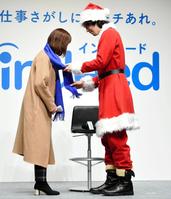 抽選で当選した一般参加者（左）にクリスマスプレゼントのマフラーを直接かける斎藤工＝東京・渋谷ヒカリエ（撮影・開出牧）