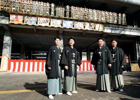 　ロームシアター京都に掲げられた看板と記念撮影する（左から）中村歌之助、中村橋之助、中村芝翫、中村福之助＝京都市