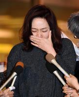 　会見で涙を見せる藤吉久美子＝１４日、羽田空港