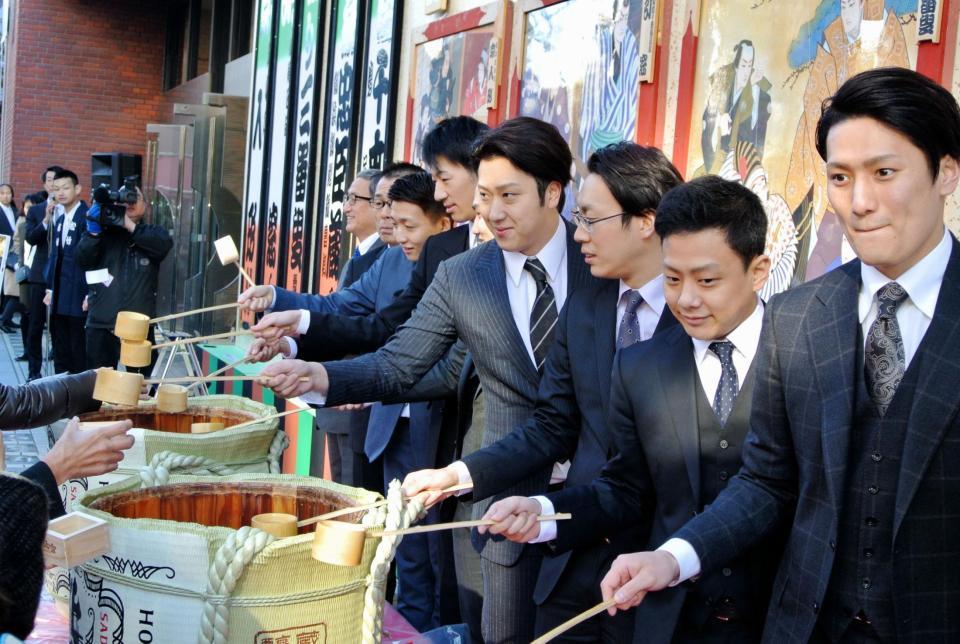 新春の祝い酒をファンに振る舞う尾上松也（中央）＝東京・浅草公会堂