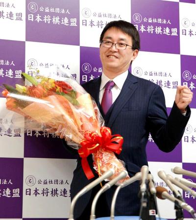 　記者会見で花束を手にガッツポーズの羽生善治氏＝東京・日本将棋会館（撮影・開出牧）