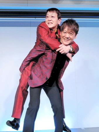 　幼少期に受けた父・渡辺英気さん（左）を背負って発声するレッスンを再現する北山たけし＝東京・品川