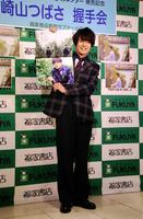 沖縄で撮影したカレンダーをアピールした崎山つばさ＝東京・福家書店新宿サブナード店