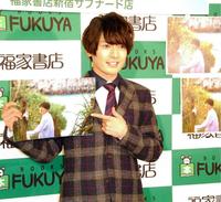 沖縄で撮影したカレンダーをアピールした崎山つばさ＝東京・福家書店新宿サブナード店