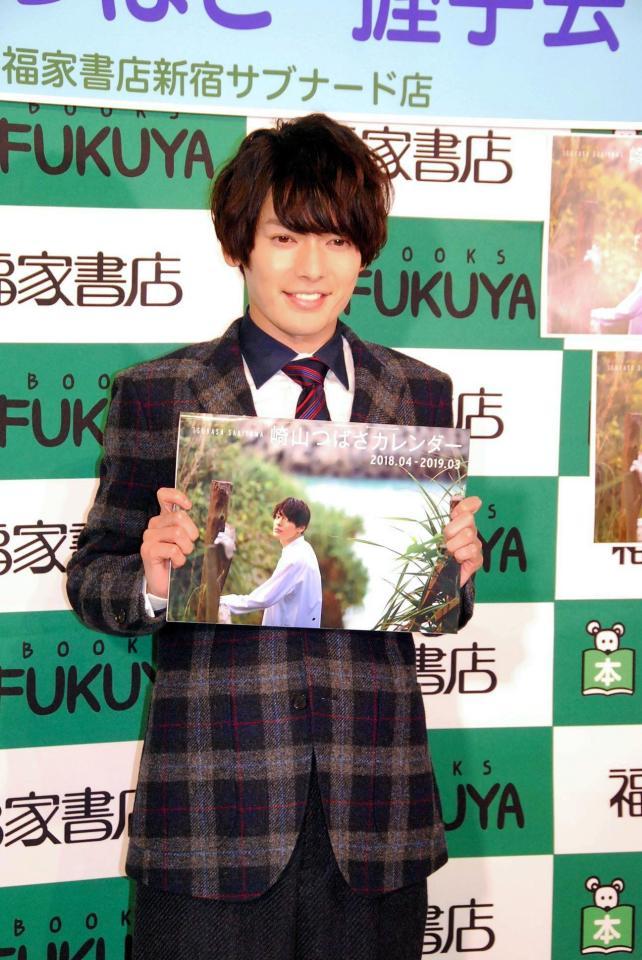 沖縄で撮影したカレンダーをアピールした崎山つばさ＝東京・福家書店新宿サブナード店