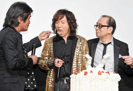 松崎しげる（左）からバースデーケーキを食べさせてもらうダイアモンド・ユカイ。右は大野雄二＝東京・神楽座