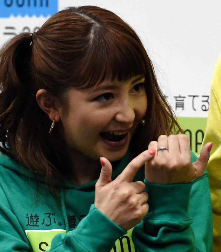 囲み取材で婚約指輪を指さし笑顔の矢口