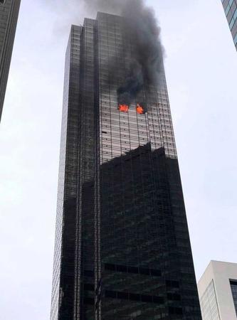 ７日、米ニューヨークで高層階から炎を上げるトランプタワー（ゲッティ＝共同）