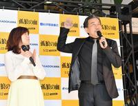 映画「孤狼の血」公開記念特別展のテープカットに登場し、注目する人々に手を振る役所広司（左は柚月裕子氏）＝東京・新宿の紀伊國屋書店（撮影・西岡正）