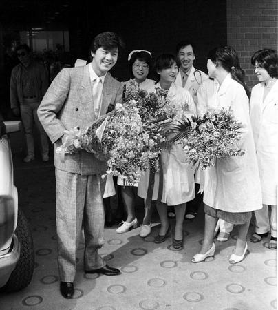 １９８４年３月９日、退院会見で花束を手に笑顔を見せる西城秀樹さん（左））