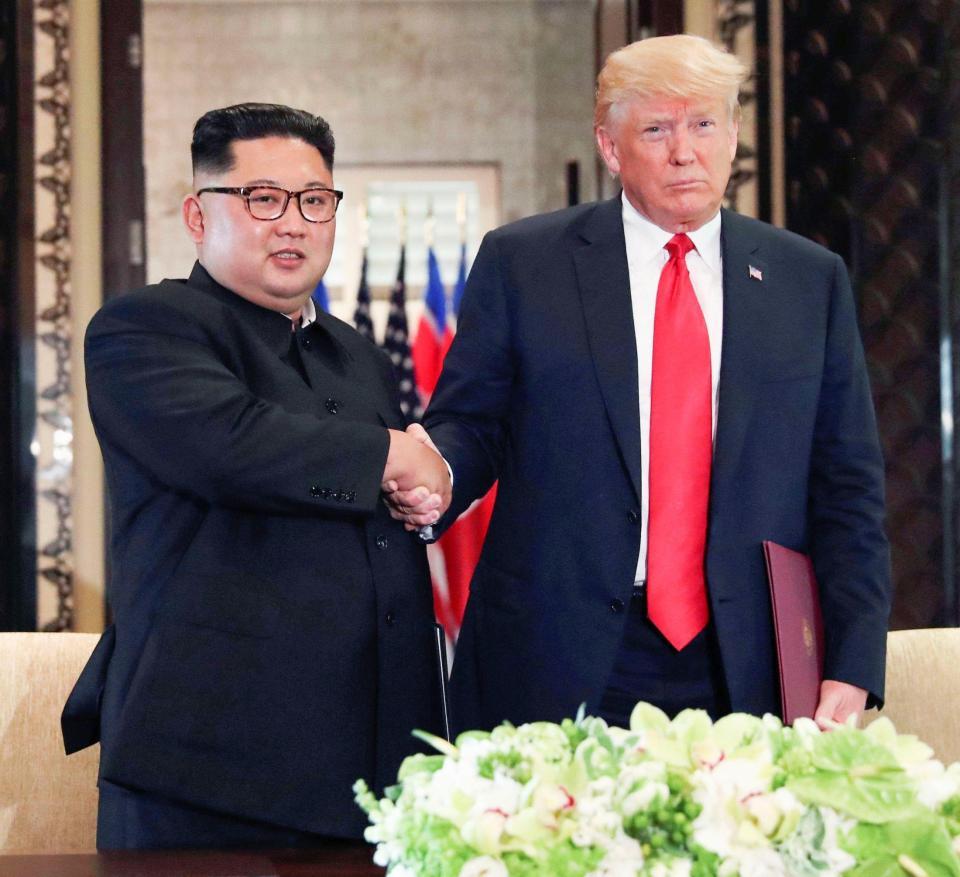 　合意文書を交換し、握手する北朝鮮の金正恩朝鮮労働党委員長（左）とトランプ米大統領＝12日、シンガポール（ロイター＝共同）