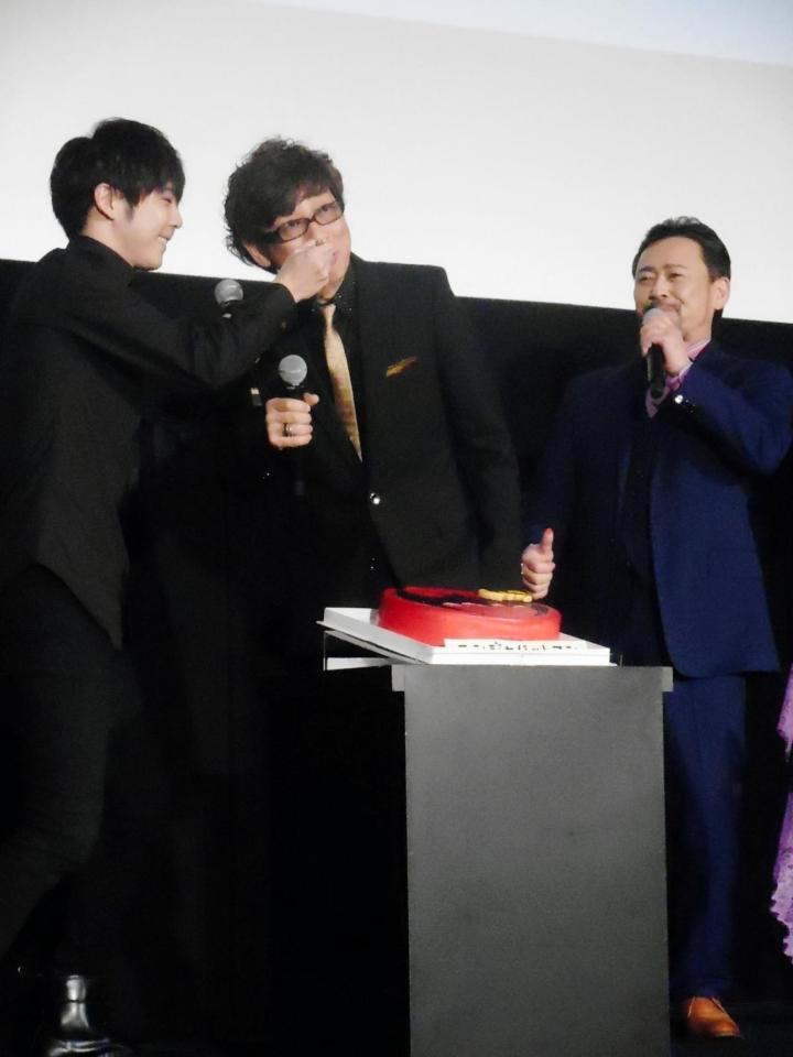 「ニンジャバットマン」公開記念舞台あいさつで、梶裕貴（左）からケーキを食べさせてもらう１７日が誕生日の山寺宏一（中央。右は高木渉）＝東京・新宿