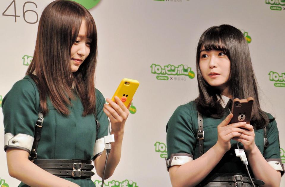 スマホでＬＩＮＥ　Ｐａｙを試す欅坂４６の菅井友香（左）と長濱ねる＝東京・新宿