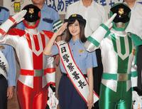 パトレン１号、２号とともに敬礼する奥山かずさ＝横浜市内