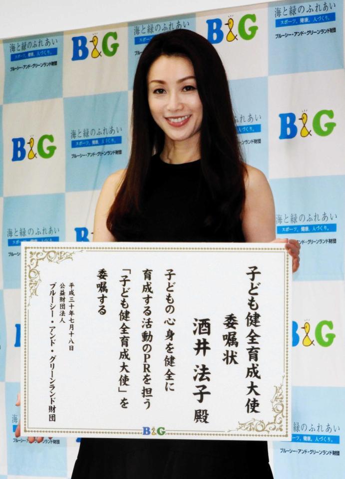 　「子ども健全育成大使」委嘱状を手に笑顔を見せる酒井法子＝東京・日本財団ビル