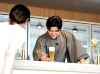 　ビアサーブを行い、女性客にビールを差し出す鈴木亮平