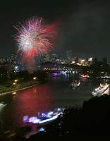 夜空を染める奉納花火の下、大川を船が行き交う天神祭の「船渡御」＝25日夜、大阪市