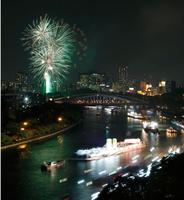 奉納花火が夜空を染める大川を、船が行き交う天神祭の「船渡御」＝25日夜、大阪市