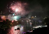 夜空を染める奉納花火の下、大川を船が行き交う天神祭の「船渡御」＝25日夜、大阪市