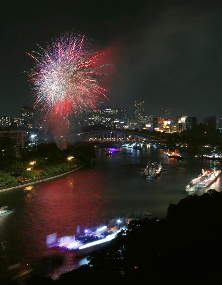 夜空を染める奉納花火の下、大川を船が行き交う天神祭の「船渡御」＝25日夜、大阪市